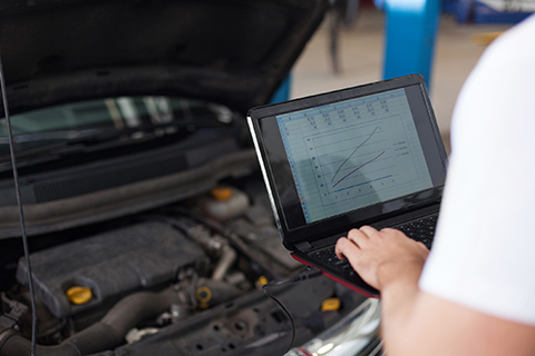 Man inspecting engine diagnosis results on his laptop